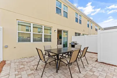 a patio with a table and chairs in front of a building at 5129 Tasty renovated 8 guests BBQ near Disney in Kissimmee