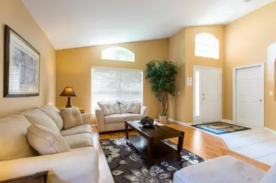 a living room with a couch and a table at Eva Kingdom back to forest home close to disney in Kissimmee