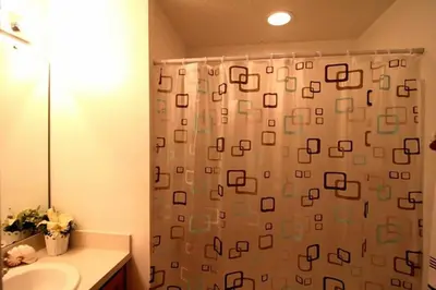 a bathroom with a shower curtain and a sink at Eva Kingdom back to forest home close to disney in Kissimmee