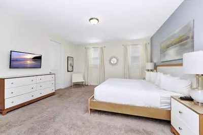 a white bedroom with a bed and a tv at Cheerful Home Near Disney With Themed Rooms, Pool Table & Waterpark And Resort Access At Encore Resorts Reunion - 200Mn in Kissimmee