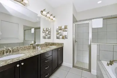 a bathroom with two sinks and a shower at Cheerful Home Near Disney With Themed Rooms, Pool Table & Waterpark And Resort Access At Encore Resorts Reunion - 200Mn in Kissimmee