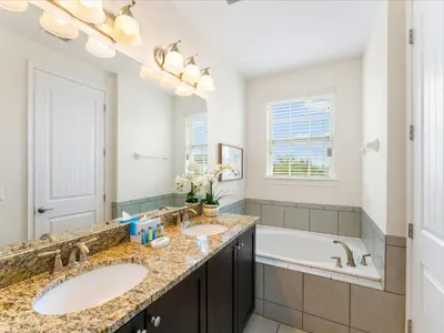 a bathroom with two sinks and a bath tub at Cheerful Home Near Disney With Themed Rooms, Pool Table & Waterpark And Resort Access At Encore Resorts Reunion - 200Mn in Kissimmee