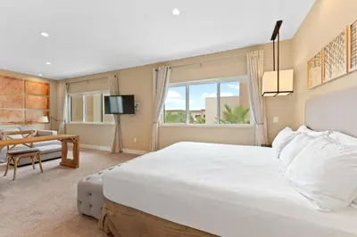 a bedroom with a large white bed and a table at 7478 Magic Village 8guests 4suites 8min Disney in Orlando