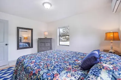 a bedroom with a bed and a dresser and a mirror at 6 Mi to Downtown Orlando Quiet Home with Sunroom in Orlando
