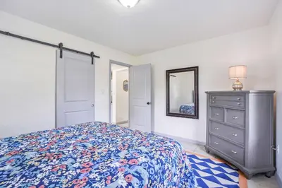 a bedroom with a bed and a dresser and a mirror at 6 Mi to Downtown Orlando Quiet Home with Sunroom in Orlando