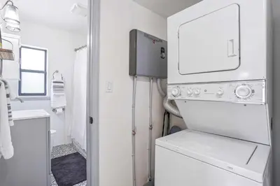a white laundry room with a washer and dryer at 6 Mi to Downtown Orlando Quiet Home with Sunroom in Orlando