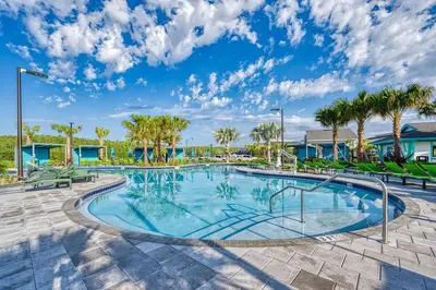 a swimming pool with trees and palm trees at Families Deluxe Dream Vacation 10 min from Disney in Kissimmee