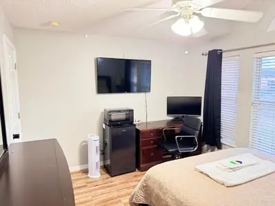 a bedroom with a bed and a desk and a television at Near Disney cozy quiet place 2 privet rooms queen bed up to 4 people in Orlando