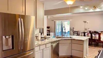 a kitchen with a stainless steel refrigerator and white cabinets at Near Disney cozy quiet place 2 privet rooms queen bed up to 4 people in Orlando