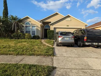 two cars parked in front of a house at Near Disney cozy quiet place 2 privet rooms queen bed up to 4 people in Orlando