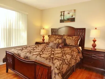 a bedroom with a large bed and two lamps at Edwin Island - Luxury home, Excellent location, Gated-Community in Kissimmee