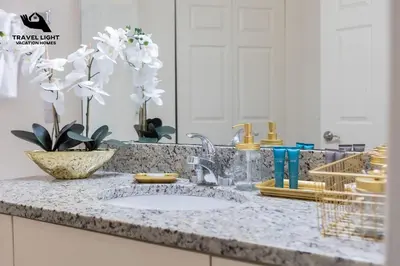 a bathroom counter with a sink and a mirror at Themed Home Near Disney World in Kissimmee