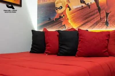 a red couch with red pillows in a room at Themed Home Near Disney World in Kissimmee