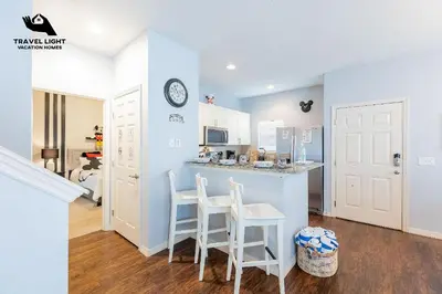 a kitchen with a counter and two stools at Themed Home Near Disney World in Kissimmee
