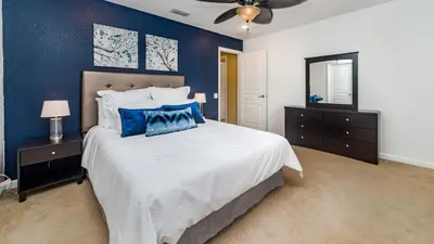 a bedroom with a large bed with blue walls at 2501 Archfeld in Kissimmee