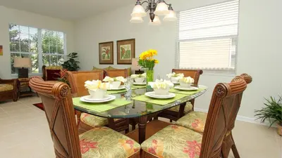 a dining room with a glass table and chairs at 2505 Archfeld in Kissimmee