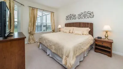 a bedroom with a bed and a tv and windows at 2566 Archfeld in Kissimmee