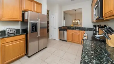 a kitchen with a stainless steel refrigerator and wooden cabinets at 2566 Archfeld in Kissimmee
