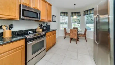 a kitchen with a stainless steel refrigerator and a table at 2566 Archfeld in Kissimmee
