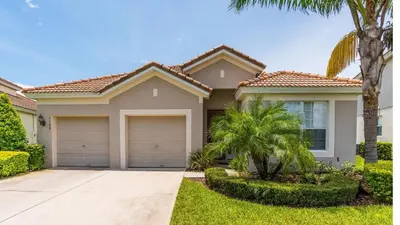 a house with two garage doors in a yard at 2568 Archfeld in Kissimmee