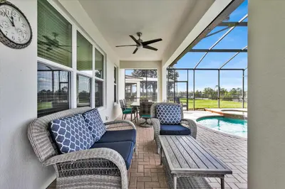 a screened in porch with a bench and a clock at 2574 Archfeld in Kissimmee