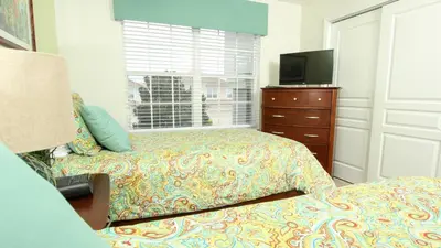 a bedroom with two beds and a tv and a dresser at 2582 Archfeld in Kissimmee