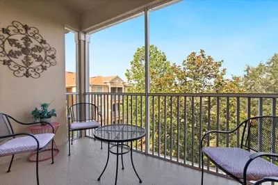 a balcony with tables and chairs and a view of a fence at 2774 Almaton #403 in Kissimmee