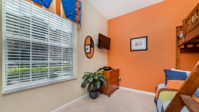 a bedroom with orange walls and a window at 2781 Almaton #103 in Kissimmee