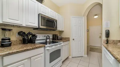 a kitchen with white cabinets and a microwave at 2781 Almaton #103 in Kissimmee