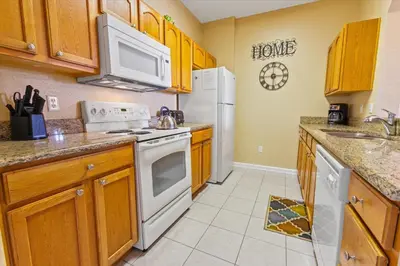 a kitchen with white appliances and wooden cabinets at 2813 Almaton #403 in Kissimmee