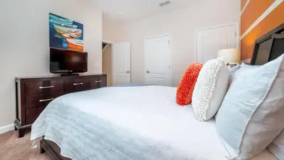 a bedroom with a white bed and a tv at 3027 Beach Palm in Kissimmee