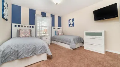 a bedroom with two beds and a flat screen tv at 3027 Beach Palm in Kissimmee