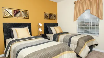 two beds in a bedroom with yellow walls at 3043 Beach Palm in Kissimmee
