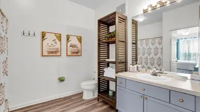 a bathroom with a sink and a toilet and a mirror at 2302 Butterfly Palm #203 in Kissimmee