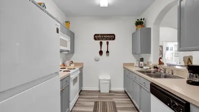 a kitchen with white cabinets and a sink at 2302 Butterfly Palm #203 in Kissimmee