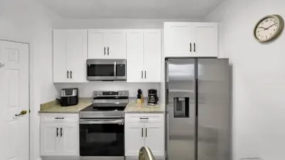 a kitchen with white cabinets and a stainless steel refrigerator at 2303 Butterfly Palm #102 in Kissimmee