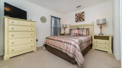 a bedroom with a bed and a dresser and a television at 7795 Basnett in Kissimmee