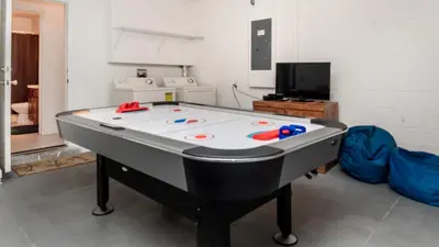 a ping pong table in a room with a tv at 7795 Basnett in Kissimmee
