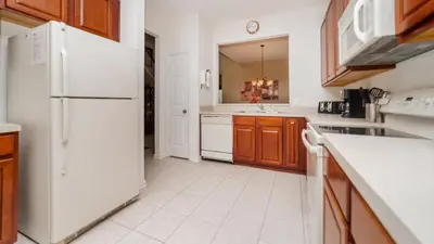 a kitchen with a white refrigerator and wooden cabinets at 7795 Basnett in Kissimmee