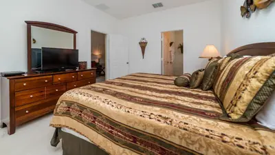 a bedroom with a bed and a dresser with a mirror at 7795 Basnett in Kissimmee
