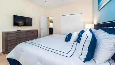 a bedroom with a large white bed with a television at 2979 Buccaneer Palm in Kissimmee