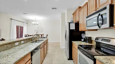 a kitchen with wooden cabinets and a black refrigerator at 8959 California Palm in Kissimmee