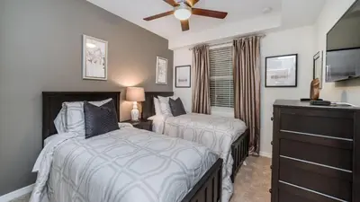 a bedroom with two beds and a ceiling fan at 4741 Clock Tower #102 in Kissimmee