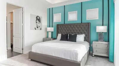 a bedroom with a large bed with blue walls at 4751 Clock Tower #401 in Kissimmee