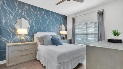 a bedroom with a bed and a blue wall at 3070 Gatsby in Kissimmee