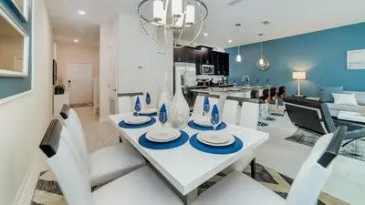 a dining room and kitchen with a white table and chairs at 3076 Juliet in Kissimmee