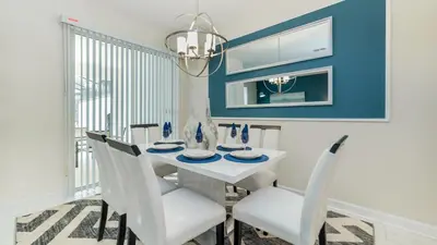 a dining room with a white table and chairs at 3076 Juliet in Kissimmee
