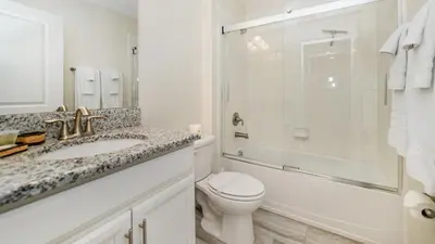 a bathroom with a sink and a toilet and a shower at 4749 Kings Castle in Kissimmee