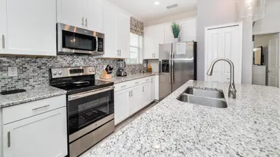 a kitchen with white cabinets and a sink and appliances at 4749 Kings Castle in Kissimmee