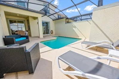 a house with a swimming pool and some chairs at 4837 Lullaby in Kissimmee